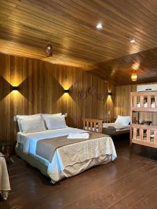 ManacapuruManati Lodge的一间卧室设有两张床和木墙