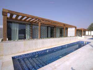 沙迦AL JUNAIDI FARM BY BRIDGE RETREATS的一座房子,旁边设有游泳池