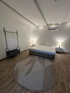 Z̧abyahاستراحة بمسبح وملعب صابوني的一间卧室配有一张床和一张大地毯