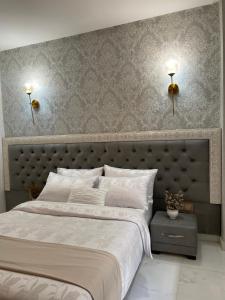 TaounateHotel Golden Star的一间卧室配有一张大床,墙上有两盏灯