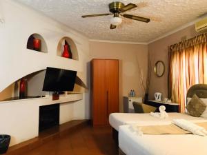 弗朗西斯敦Inca Rose Guest House的酒店客房设有两张床和一台平面电视。