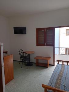埃尔泰勒罗Pension Alvarez的客房设有1张床、1张桌子和1台电视。