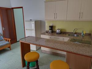 埃尔泰勒罗Pension Alvarez的厨房配有柜台、水槽和2把凳子