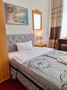 柏林柏林膳食公寓酒店的一间卧室配有一张带白色毯子的大床