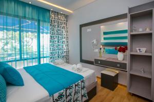 阿斯特里斯Astris Beach的一间卧室设有蓝色的床和窗户。