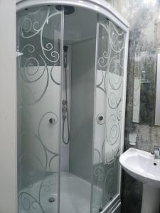 塔什干Comfortable Apartment的水槽旁的玻璃门淋浴