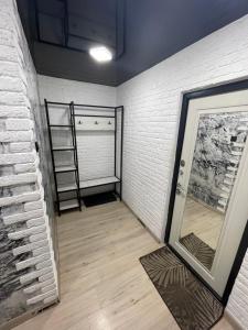 乌斯季卡缅诺戈尔斯克1-комнатная квартира Виноградова 12的一间设有白色砖墙和镜子的客房