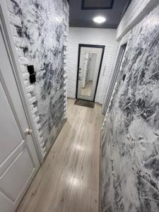 乌斯季卡缅诺戈尔斯克1-комнатная квартира Виноградова 12的一条带白色砖墙和门的走廊