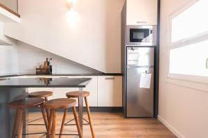 查韦斯Alojamento Porta14.4的厨房配有柜台、冰箱和凳子