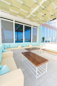 杜拉特阿拉尔Tiffany Beach的客厅配有白色家具和桌子