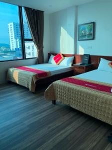 格卢市社Khách sạn An Phú Cửa Lò的酒店客房设有两张床和窗户。