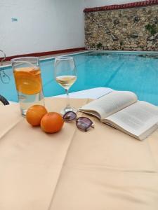 内瓦HOTEL DINASTIA REAL NEIVA的一张桌子,上面放着一杯葡萄酒和一本书