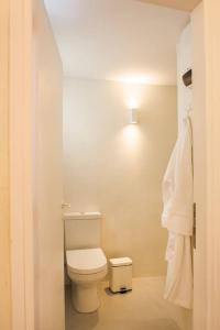 伊兹拉NESEA Boutique Apartments的浴室配有卫生间和墙上的灯。