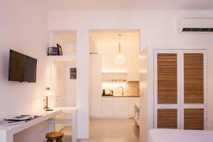 伊兹拉NESEA Boutique Apartments的白色的客房设有书桌和厨房