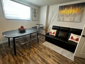 魁北克市Refuge urbain à Beauport的客厅配有黑色沙发和桌子
