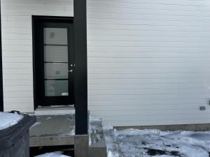 魁北克市Refuge urbain à Beauport的房子边的黑色门