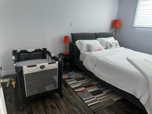 魁北克市Refuge urbain à Beauport的一间卧室配有一张床和一张带台灯的桌子