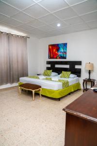 圣萨尔瓦多圣贝尼托-索娜罗莎套房及公寓的一间卧室配有两张床、一张桌子和一张书桌