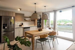 普拉纳维瑙Blue Venao Beach Bliss Retreat / Condo E21的带木桌和椅子的厨房以及带阳台的厨房。