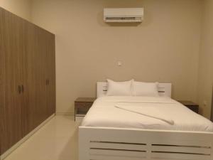 塞拉莱Star Dubai Apartment的卧室配有白色的床和空调
