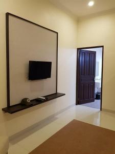 PasarbaruNew Belitung Holiday Resort的一间设有镜子和墙上电视的房间