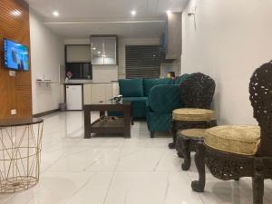 拉合尔Homey Stays - 2 Bedroom Apartment - Gulberg的客厅配有绿色沙发和桌子