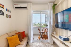 约恩维利EAO - Apartamentos completos em Joinville/SC的带沙发和窗户的客厅