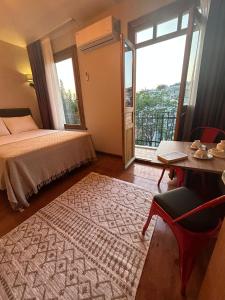 伊斯坦布尔NarPera Taksim Boutique Hotel的一间卧室配有一张床、一张桌子和一个窗户。