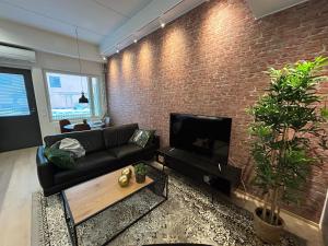 库奥皮奥City Home Alvari, free parking, air conditioning的带沙发和砖墙的客厅