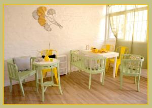 拉普拉塔Ginkgo Hostel La Plata的用餐室配有2张桌子和黄色椅子