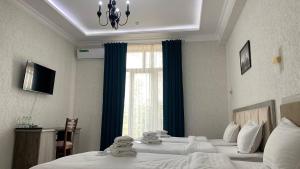 撒马尔罕OLD STATION HOTEL的酒店客房设有两张床和窗户。