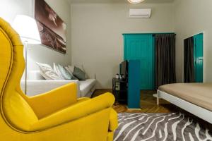 布达佩斯Cosy Apartment In Party District K30的一间卧室配有黄色椅子和一张床