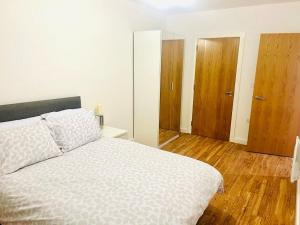 吉林汉姆A Cosy 2bedroom Apartment With River View的卧室配有一张白色大床,铺有木地板