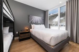 圣弗朗索瓦小河Les Appartements du Massif de Charlevoix的卧室设有一张白色大床和一扇窗户。
