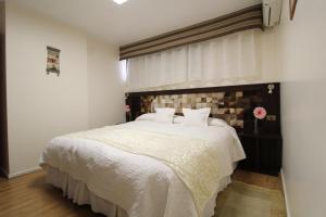 卡拉马阿坦卡拉马酒店的卧室配有一张大白色床和窗户