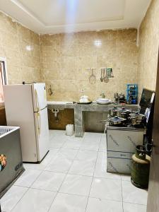 努瓦克肖特Duplex neuf meublé的厨房配有冰箱和炉灶。