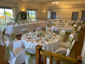 KilchattanKingarth Hotel的一间设有桌椅和白色桌布的房间