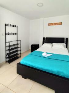 波帕扬Hermoso apartamento en Popayán的一间卧室配有一张带蓝色毯子的床