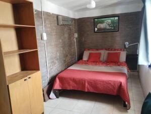卡塔马卡Bruna Departamentos的小卧室配有红色枕头的床