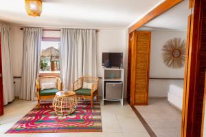 格兰德岛Hotel Isla del Sol的客厅配有桌椅和电视。