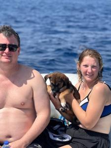 赫尔格达KUBA LuXus tour - Hotel boat in sahl Hashesh - Hurghada的和狗一起坐在船上的男人和女人