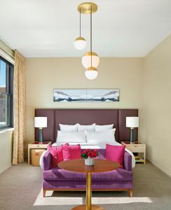 堪萨斯城21c Museum Hotel Kansas City的客厅配有紫色沙发和床。