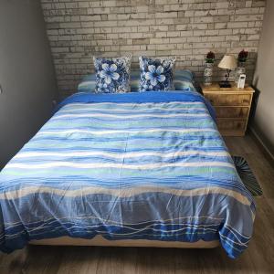 托莱多Chalet con piscina en escalona的一间卧室配有一张带蓝色和白色棉被的床