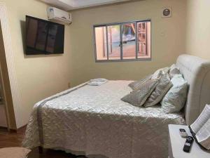 蒙蒂斯克拉鲁斯Apartamento Encantador C的一间卧室配有一张床和一台平面电视