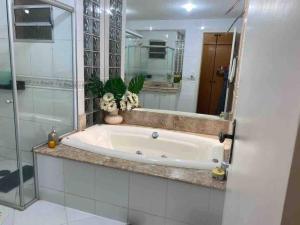 蒙蒂斯克拉鲁斯Apartamento Encantador C的带浴缸的浴室和大镜子