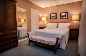 伊塔佩马Sofistic Hotel的一间卧室配有一张大床,内有长凳