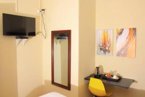 哈博罗内Kunzi B&B的一间设有镜子和黄色椅子的房间