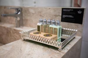 伊塔佩马Sofistic Hotel的浴室柜台上装有四瓶金属架