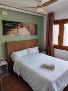 卡斯特尔比斯堡L'Olivera Casa Rural的一间卧室配有一张带白色毯子的大床