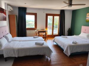 卡斯特尔比斯堡L'Olivera Casa Rural的酒店客房设有两张床和一张桌子。
